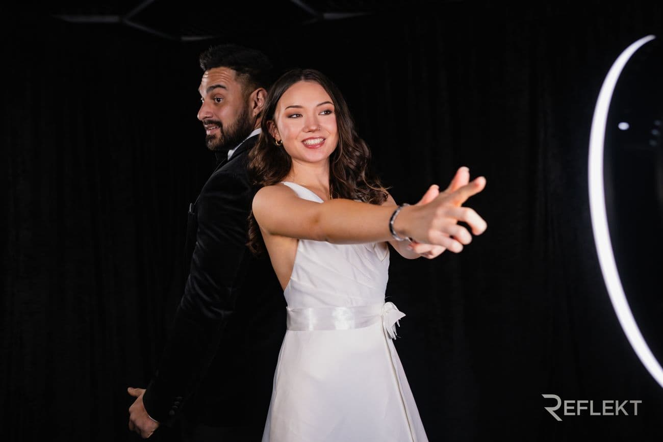 Couple dancing in front of a ring-light video booth