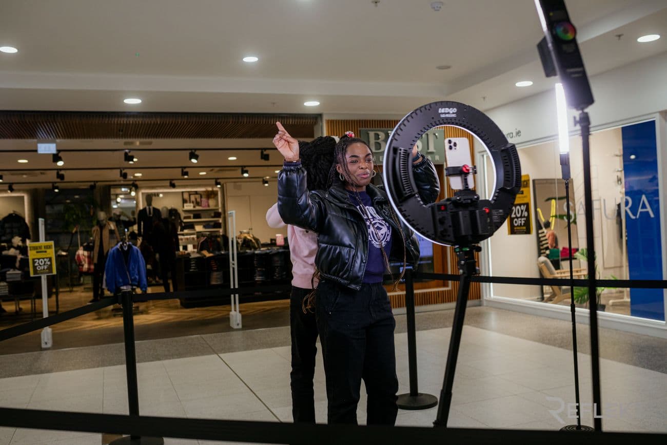 Guest posing at a ring-light video booth inside a shopping center