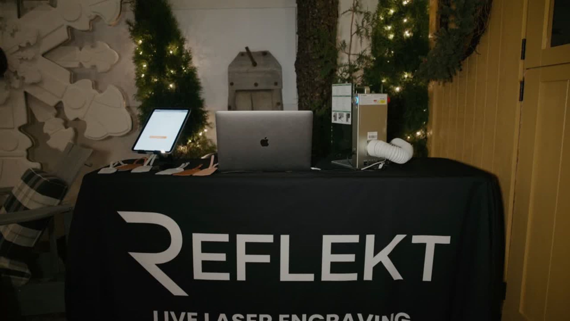 Reflekt live laser engraving station set up at a corporate holiday event